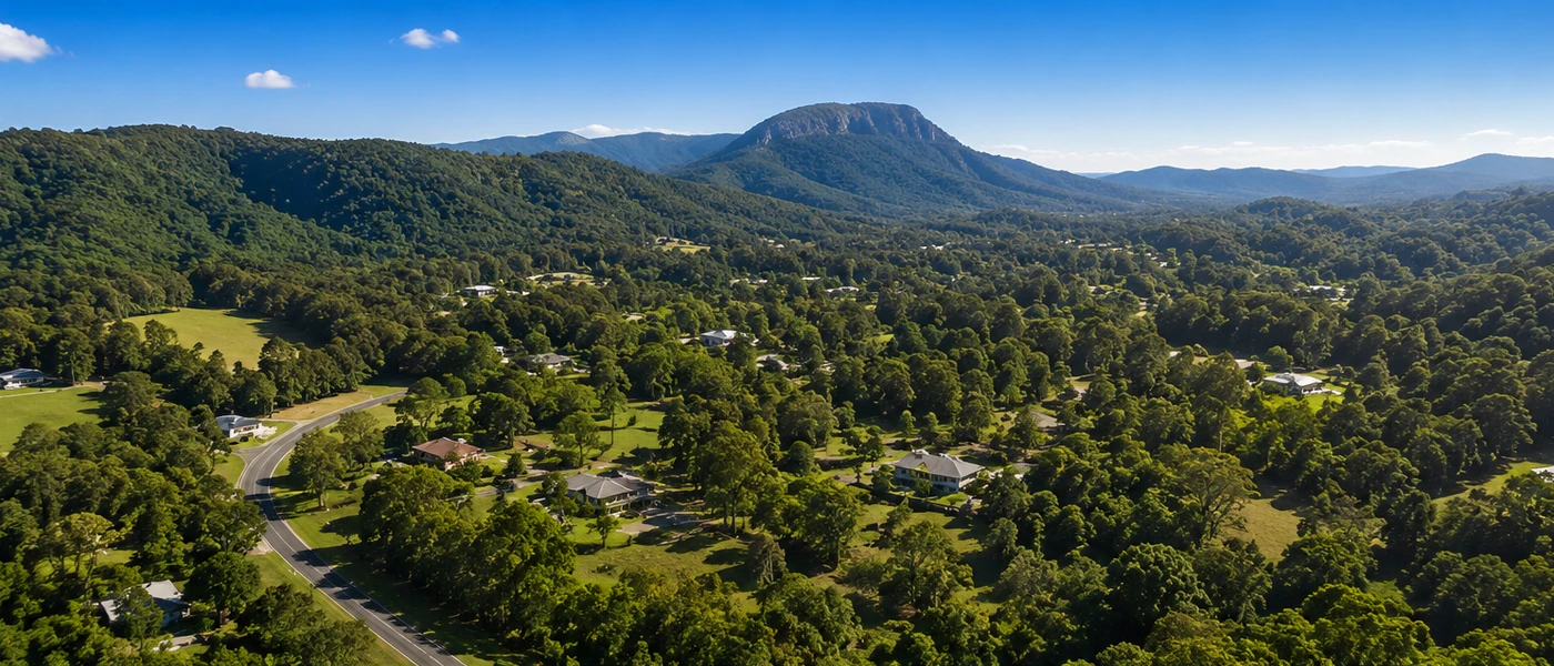 Bonogin Buyers Agent aerial view of leafy acreage homes, rolling hills and Gold Coast hinterland