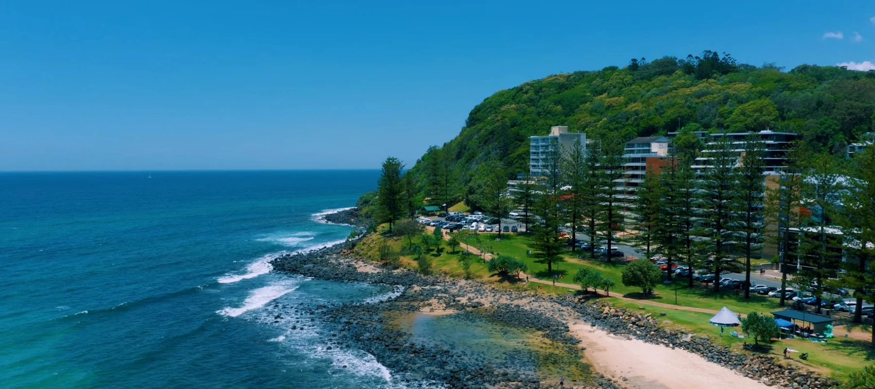 Aerial view of Burleigh Heads coastline, headland and beachside property.